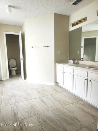a spacious bathroom with a sink and a mirror