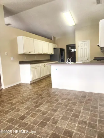 a view of a kitchen with kitchen island microwave and cabinets