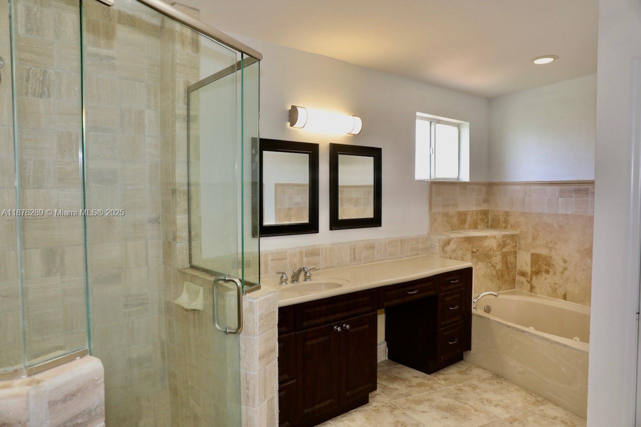 16335 Southwest 93rd Street Miami, FL 33196 - Photo 15 of 29 a bathroom with a double vanity sink a mirror and a bathtub