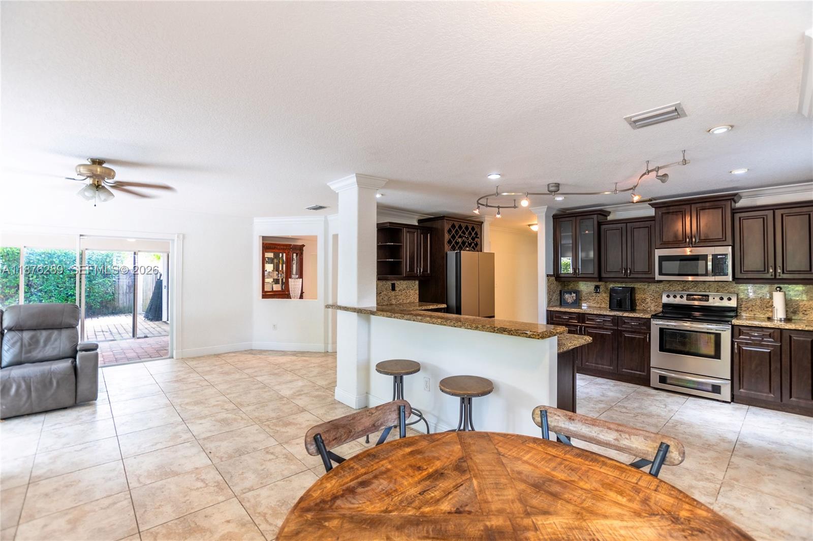 16335 Southwest 93rd Street Miami, FL 33196 - Photo 19 of 70 a living room with stainless steel appliances kitchen island granite countertop furniture and a kitchen view