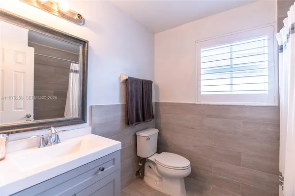 a bathroom with a tub sink and mirror