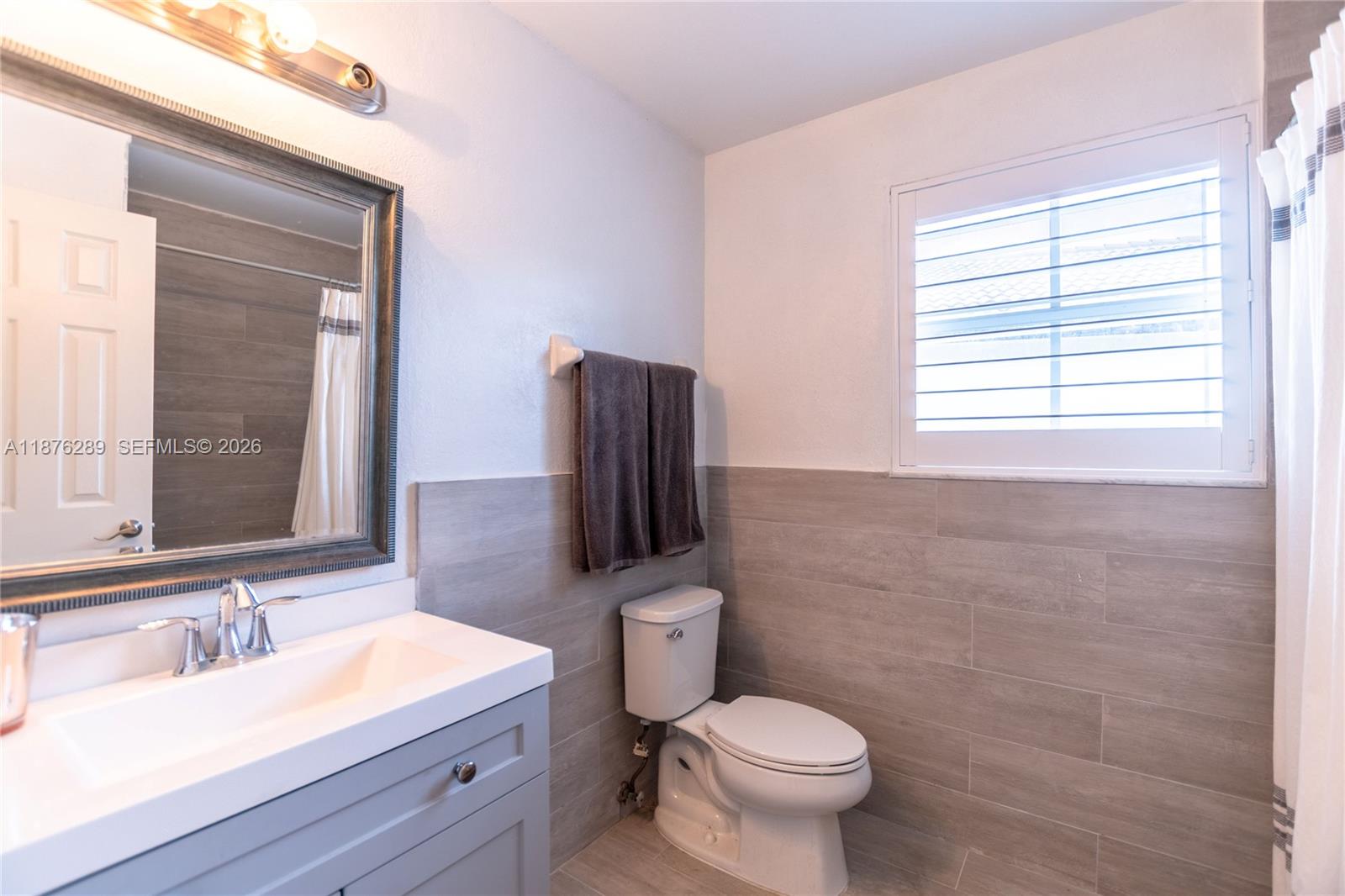 16335 Southwest 93rd Street Miami, FL 33196 - Photo 40 of 70 a bathroom with a granite countertop toilet a sink and a mirror