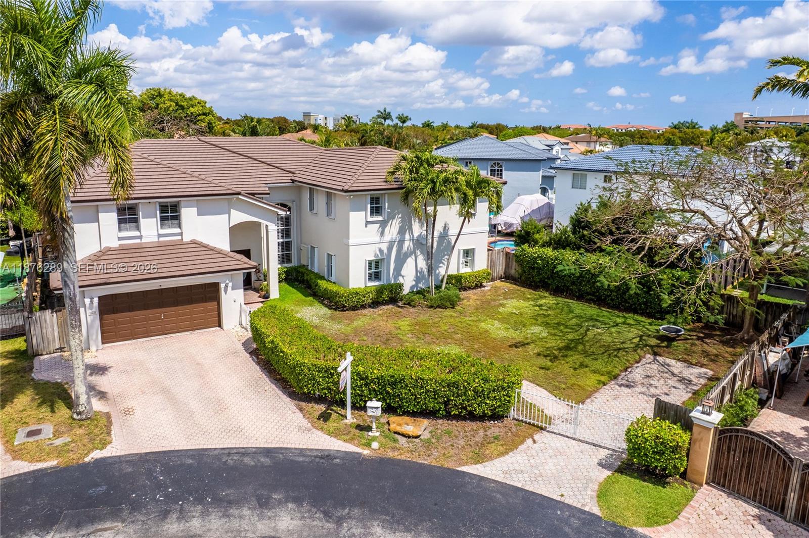 16335 Southwest 93rd Street Miami, FL 33196 - Photo 65 of 70 a view of a white house with a yard plants and large tree