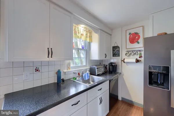 a kitchen with stainless steel appliances a microwave a sink and cabinets