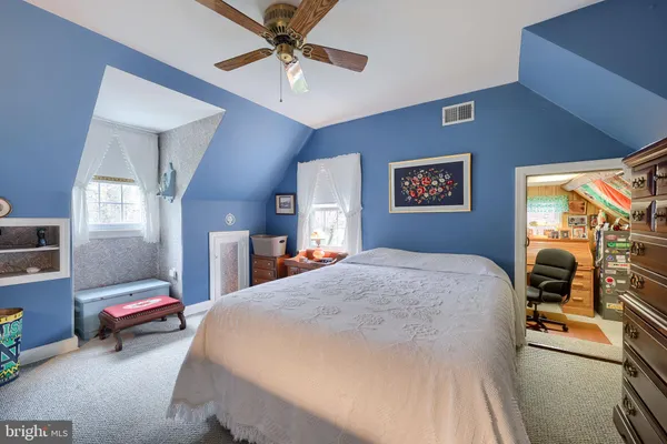 a spacious bedroom with a bed and a chandelier