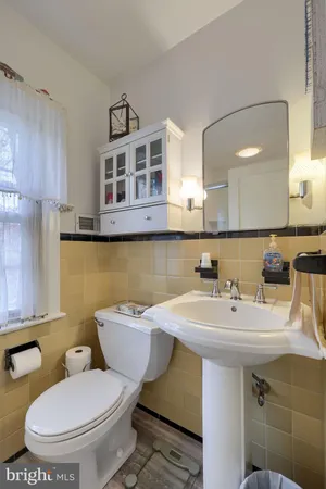 a bathroom with a sink a toilet and a mirror