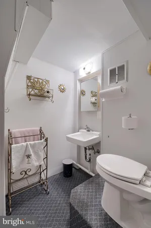 a bathroom with a sink toilet and a mirror