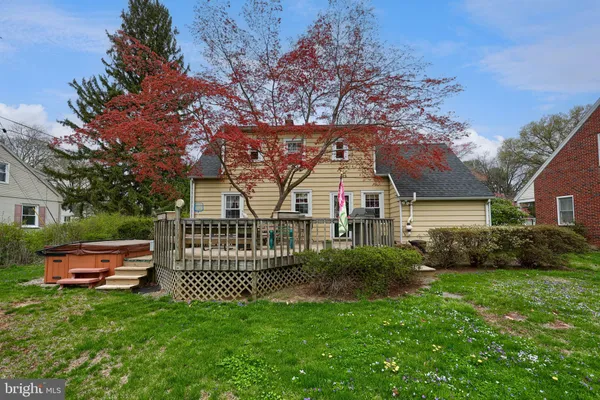 a view of a house next to a yard with big trees