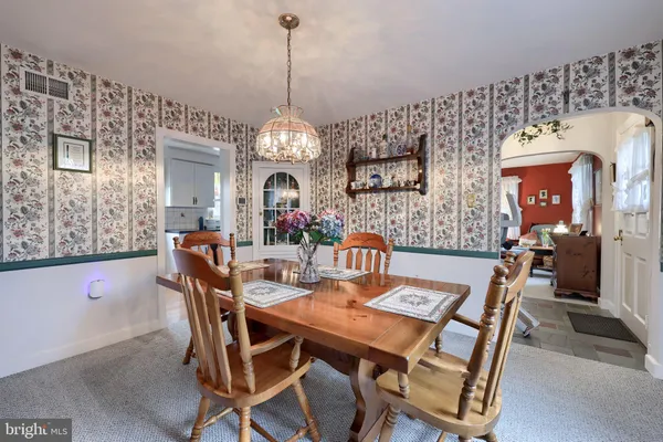 a view of a dining room with furniture and chandelier
