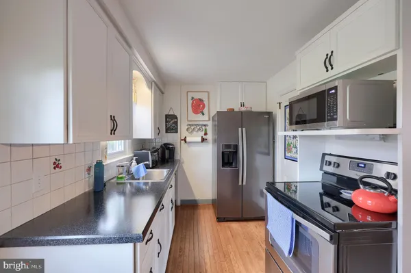 a kitchen with stainless steel appliances granite countertop a sink stove refrigerator and a microwave