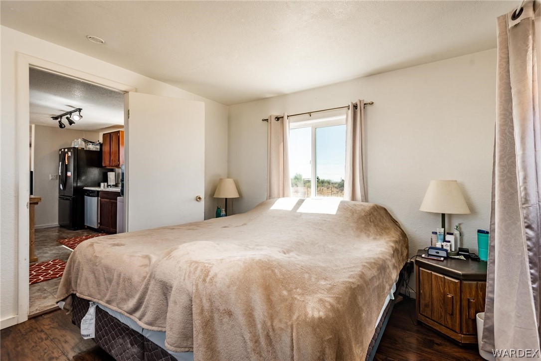 3535 Mobile Road Golden Valley, AZ 86413 - Photo 11 of 37 a bedroom with a bed and wooden floor