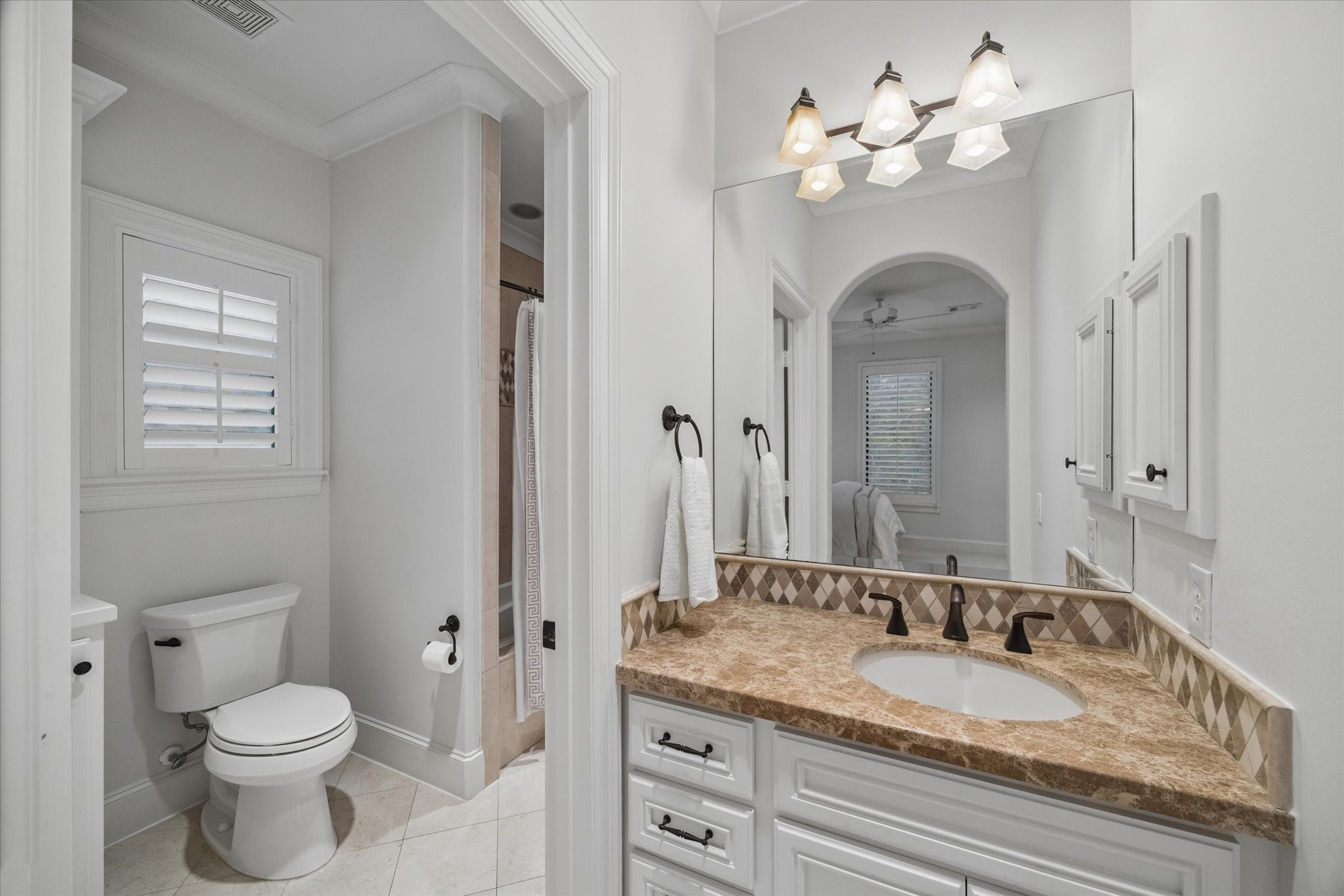 4511 Merrie Lane Bellaire, TX 77401 - Photo 35 of 49 a bathroom with a granite countertop toilet a sink and a mirror