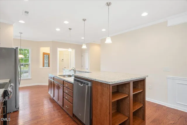 a kitchen with a stove a refrigerator a sink dishwasher with a dining table and chairs