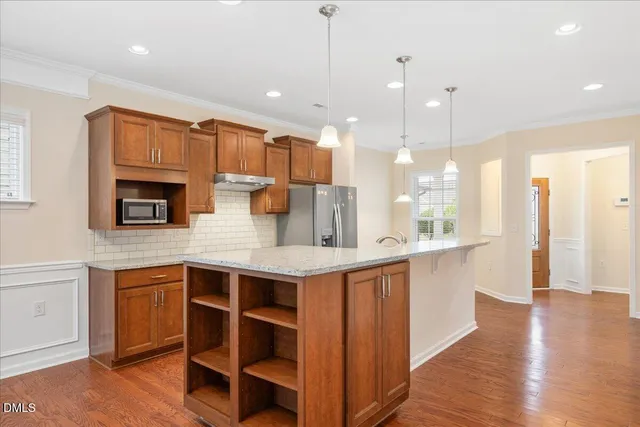 a kitchen with stainless steel appliances granite countertop a sink a stove and a wooden floors