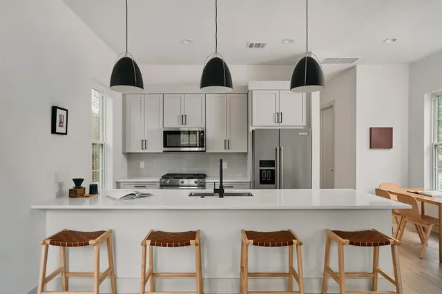 a kitchen with stainless steel appliances granite countertop a sink a stove and refrigerator