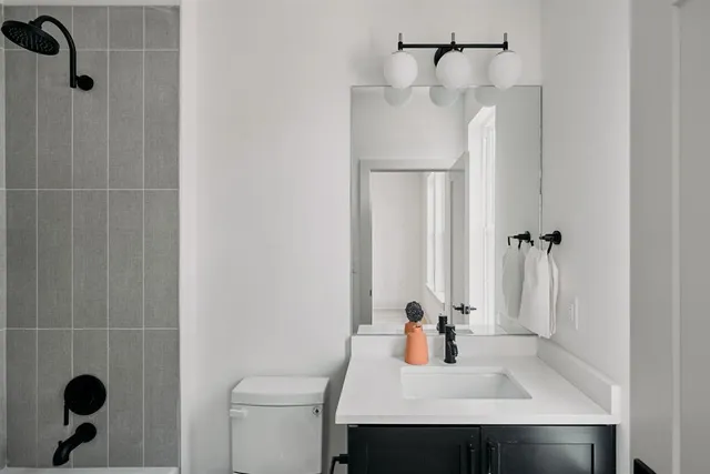 a bathroom with a sink a toilet and shower