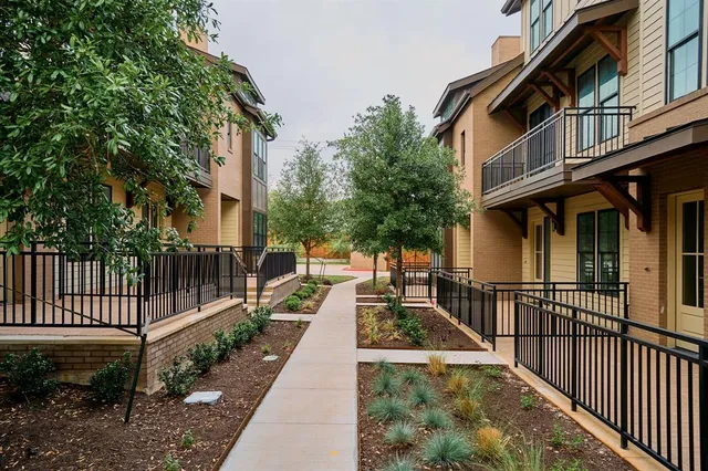 a view of a brick house with a large window and wooden fence