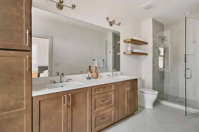 a spacious bathroom with a double vanity sink toilet and shower