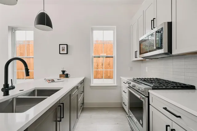 a kitchen with stainless steel appliances a stove sink and microwave