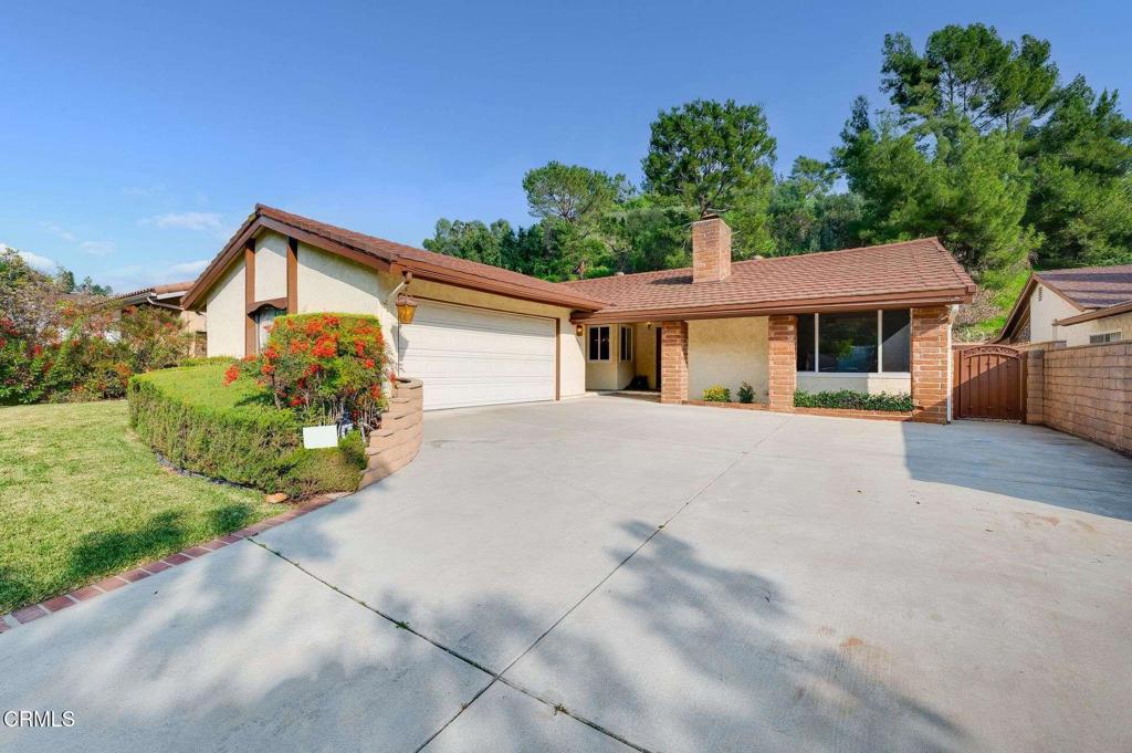 a front view of a house with a yard and potted plants