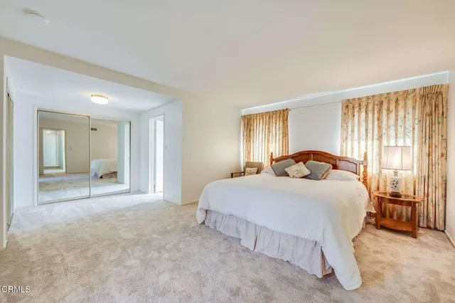 a bedroom with a bed and a large mirror