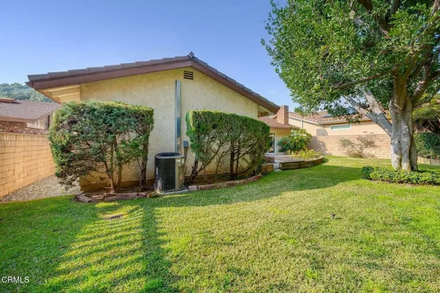 a view of a house with backyard and a tree