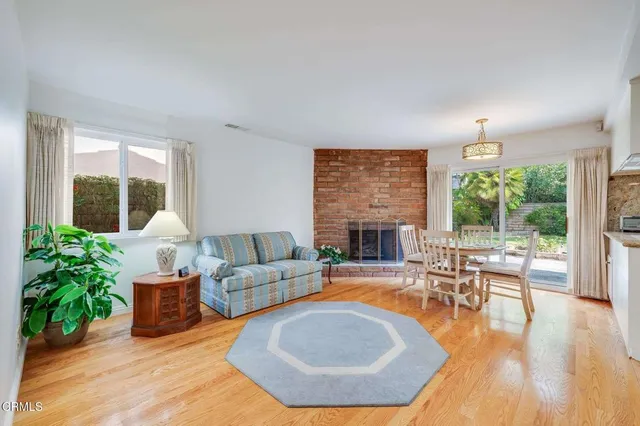 a living room with furniture a fireplace and a floor to ceiling window