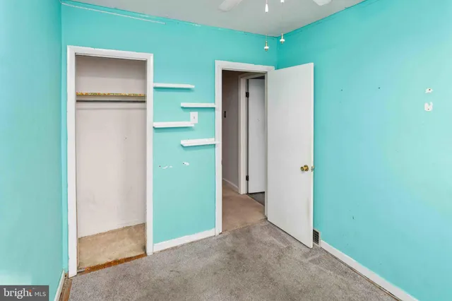 a view of an empty room with stairs and furniture