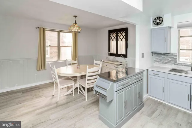 a dining room with wooden floor a chandelier a wooden table and chairs