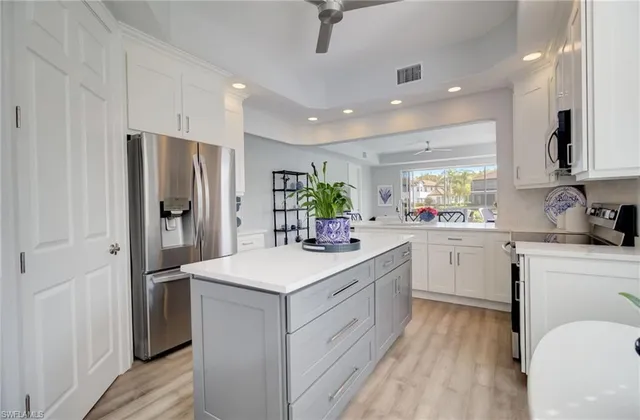 a kitchen with a sink stainless steel appliances and white cabinets