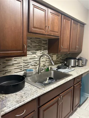 a kitchen with granite countertop a sink stainless steel appliances and cabinets