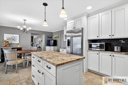 29 Darby Road East Brunswick, NJ 08816 - Photo 7 of 34 a kitchen with kitchen island granite countertop a stove a sink a center island and cabinets