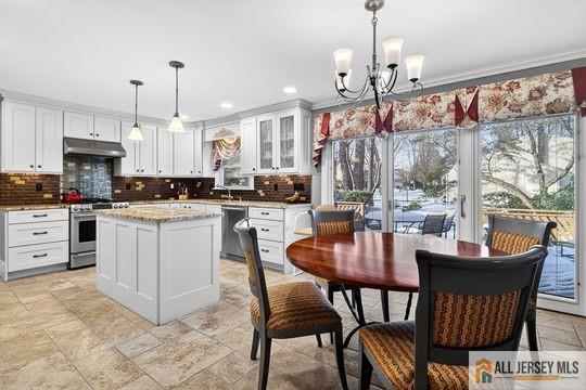 29 Darby Road East Brunswick, NJ 08816 - Photo 9 of 34 a kitchen with kitchen island granite countertop a table chairs sink and cabinets