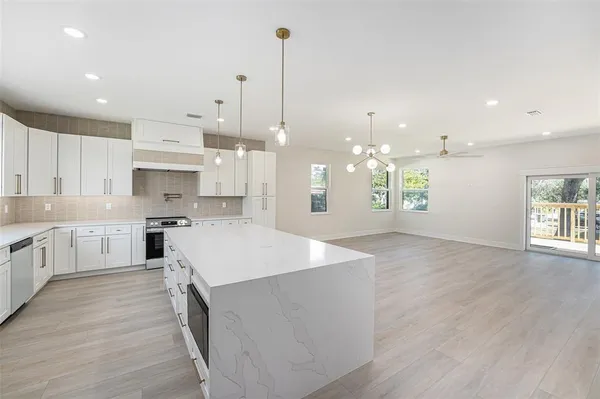 a large kitchen with kitchen island a sink table and chairs