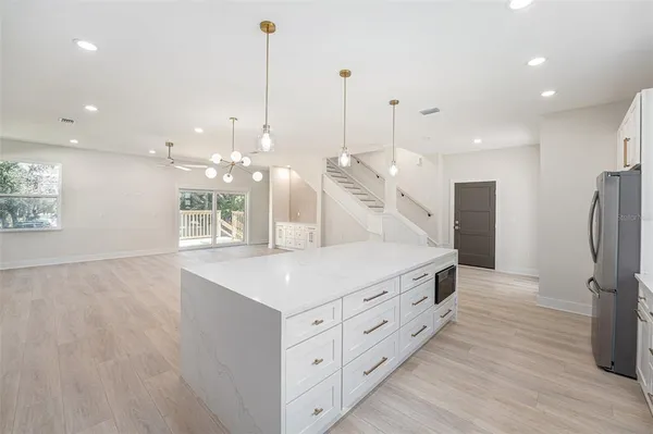 a kitchen with stainless steel appliances kitchen island a hardwood floor and a sink