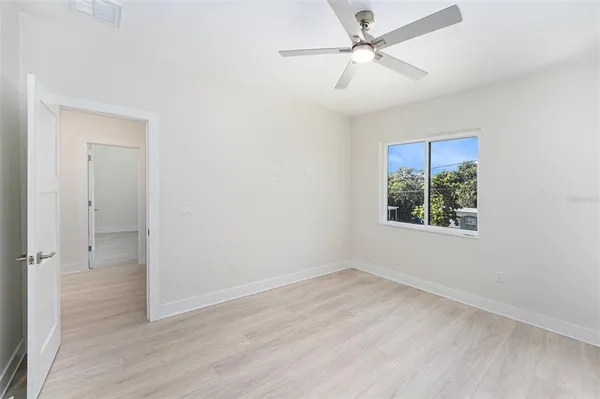an empty room with fan and windows