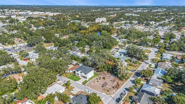 an aerial view of residential houses with outdoor space and trees