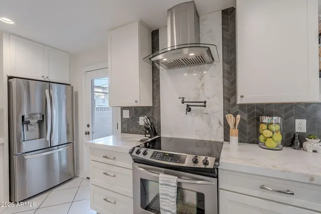 a kitchen with stainless steel appliances granite countertop a sink and a refrigerator