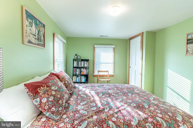 a bedroom with a bed and a large window