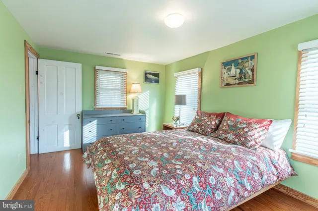 a large bed sitting in a bedroom next to a window and dresser