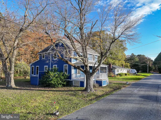 a front view of a house with a yard and trees