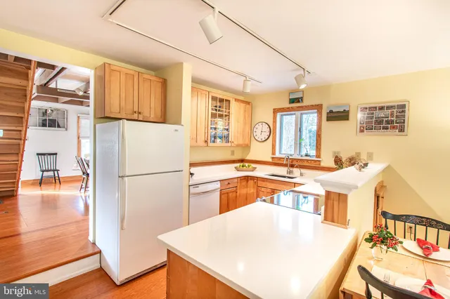 a kitchen with a refrigerator a stove a sink dishwasher and wooden cabinets