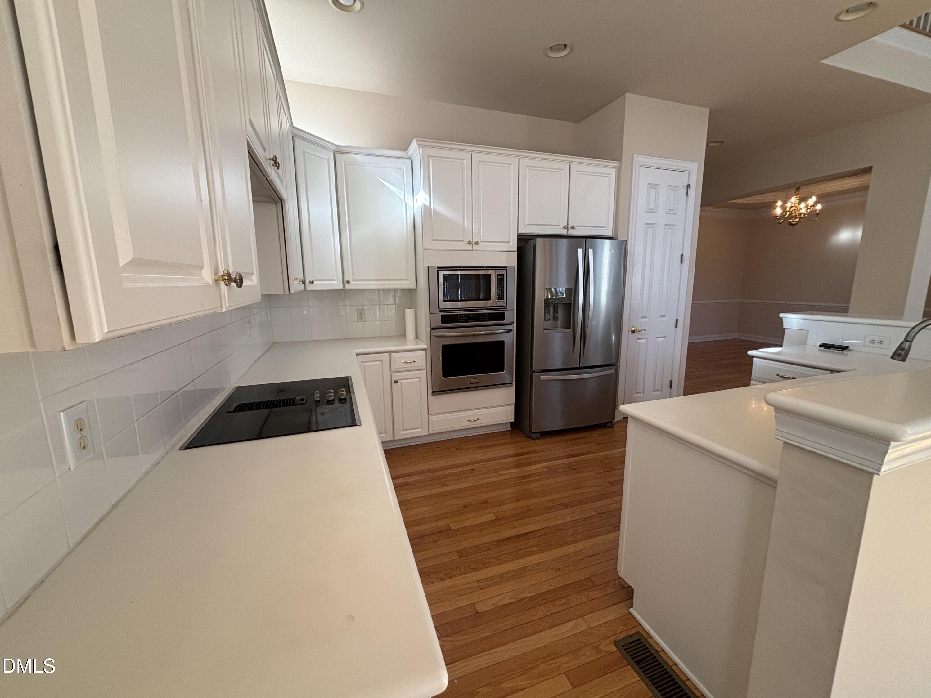 11729 Broadfield Court Raleigh, NC 27617 - Photo 14 of 47 a kitchen with a refrigerator sink and wooden floor