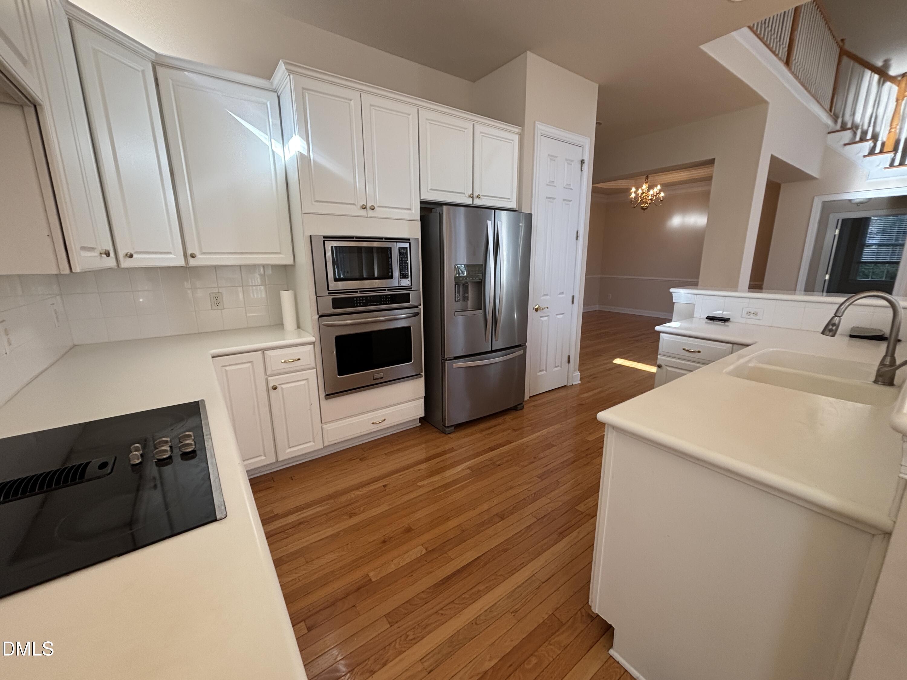 11729 Broadfield Court Raleigh, NC 27617 - Photo 4 of 47 a kitchen with stainless steel appliances a refrigerator a sink a stove and white cabinets