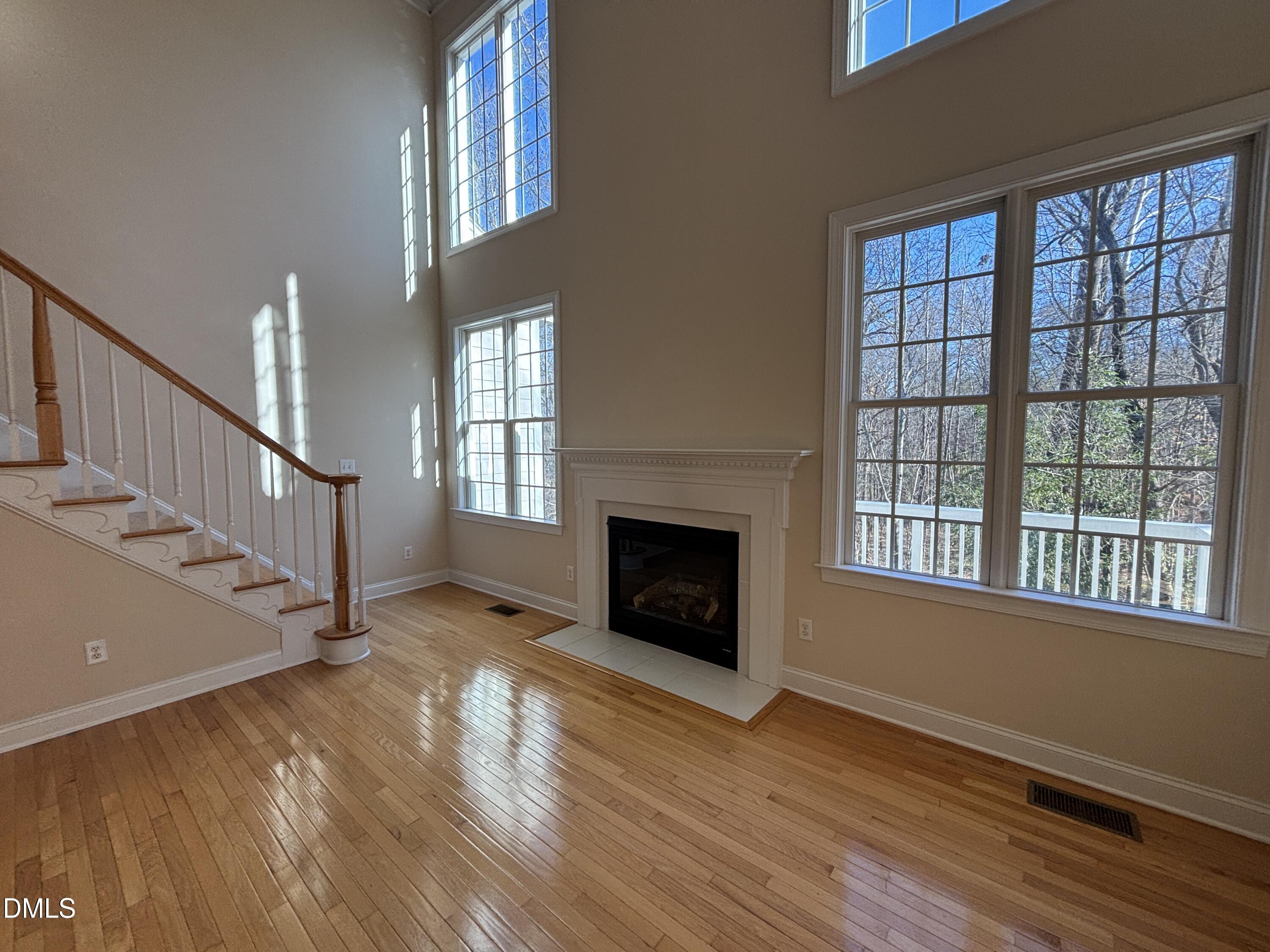 11729 Broadfield Court Raleigh, NC 27617 - Photo 6 of 47 a view of an empty room with wooden floor fireplace and a window