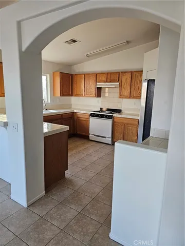 a living room with stainless steel appliances furniture a large window