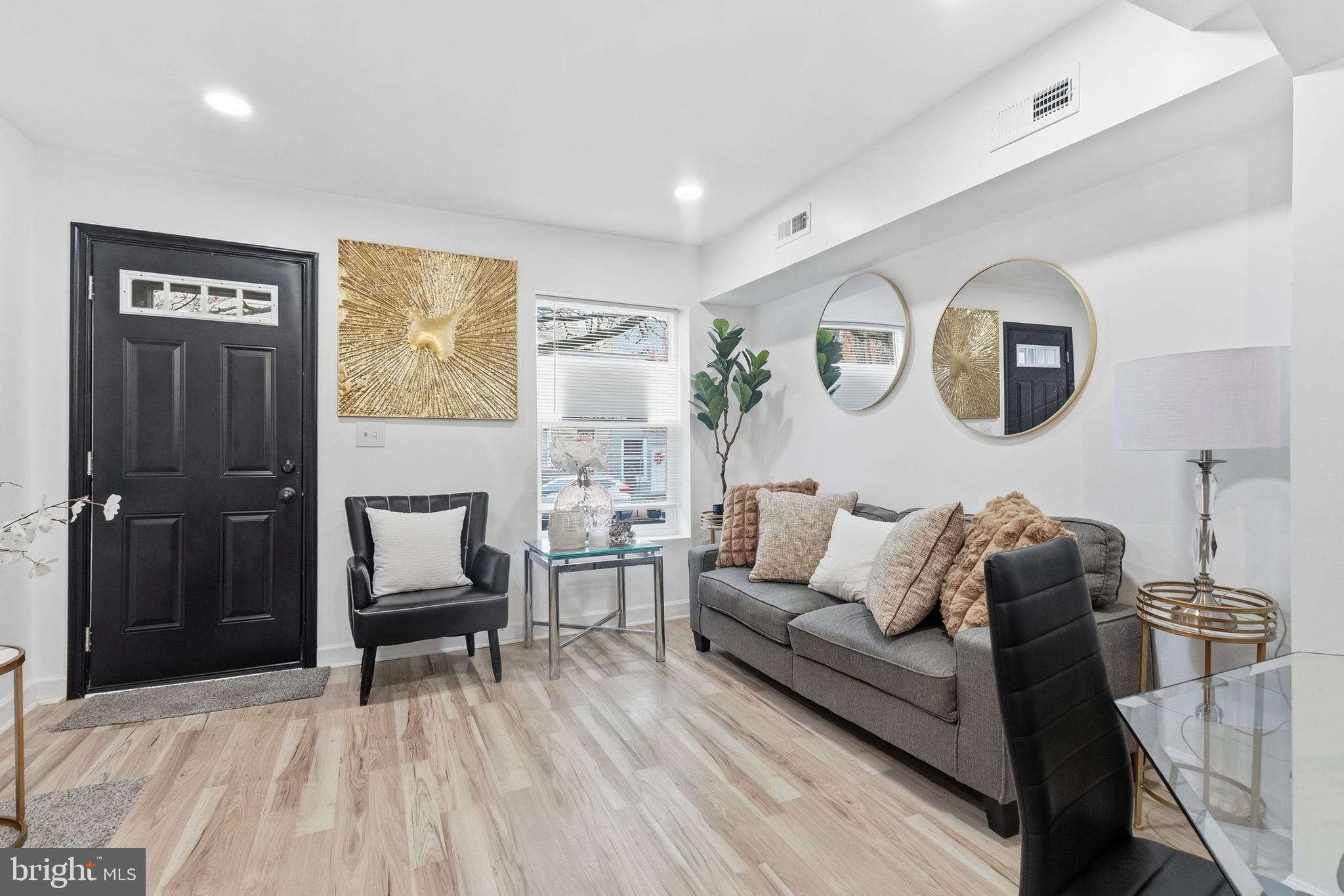 a living room with furniture and a wooden floor