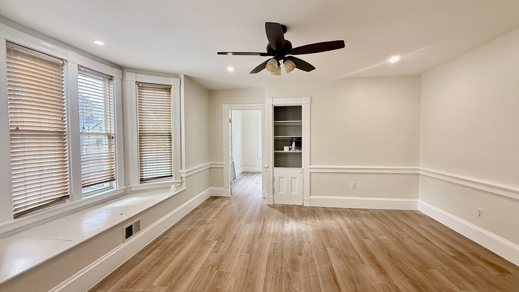 225 Pleasant Street, Unit 1 Weymouth, MA 02190 - Photo 1 of 10 a view of an empty room with a window and wooden floor