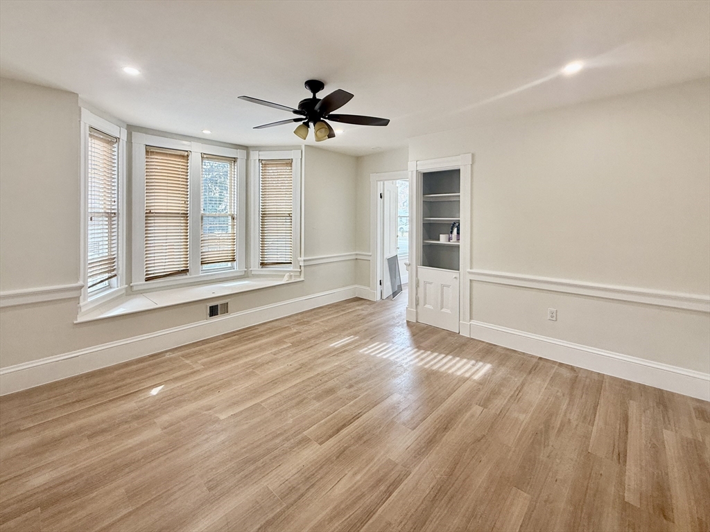 225 Pleasant Street, Unit 1 Weymouth, MA 02190 - Photo 2 of 10 a view of an empty room with a window and wooden floor