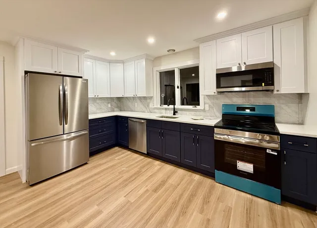 a kitchen with stainless steel appliances granite countertop a refrigerator stove a sink dishwasher and microwave with wooden floor